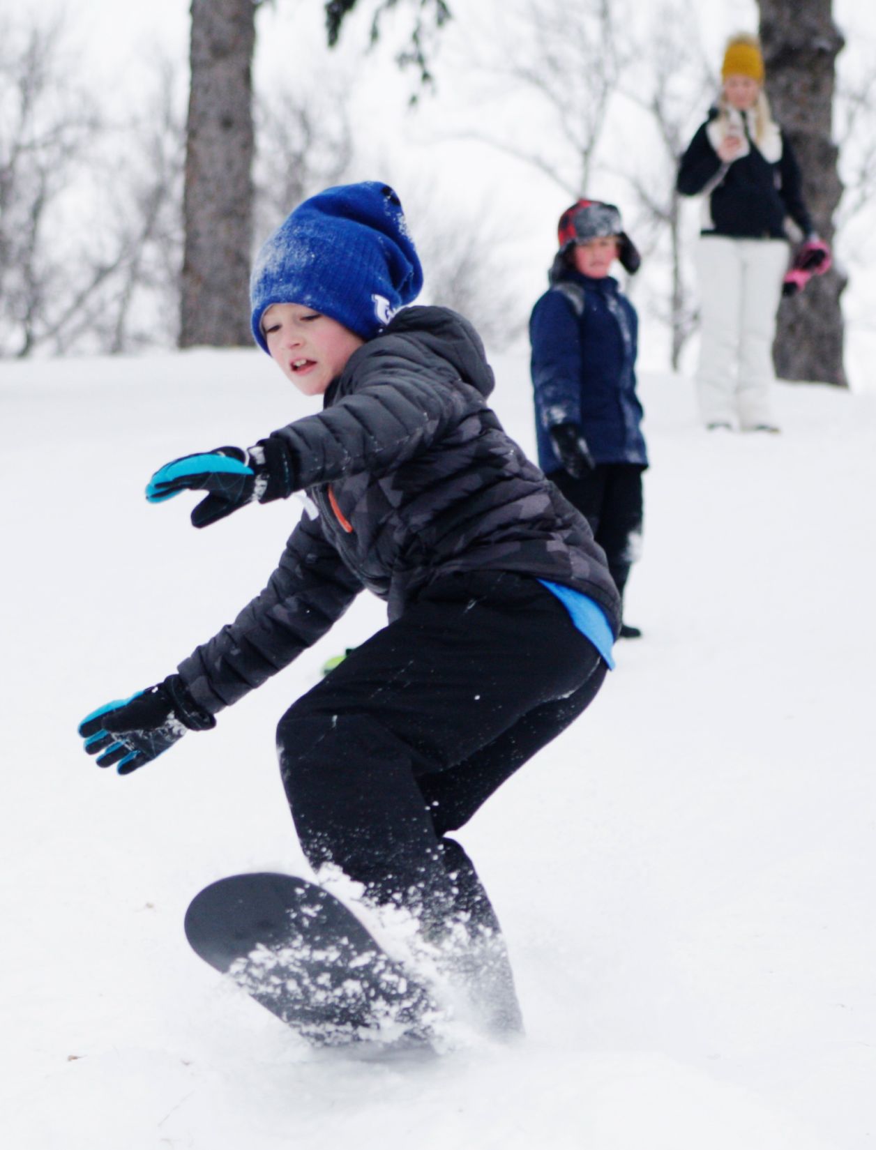 Will Millard, 9, snowboards down a hill